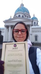 Sandra Chander com o certificado de sua formação de instrutora de ThetaHealing® Ritmo e Peso Perfeito, realizada na Rússia em 2017.